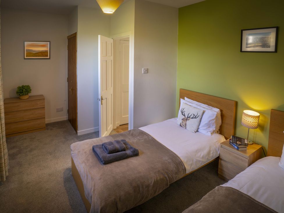 A bedroom with two single beds and a nightstand at Clayhills Cottage in Blairgowrie