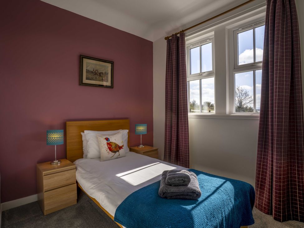 A bedroom with a bed and bedside tables at Clayhills Cottage in Blairgowrie