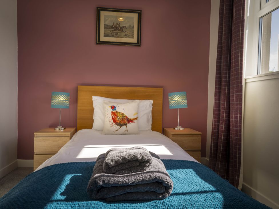 A bedroom with a single bed and a lamp at Clayhills Cottage in Blairgowrie