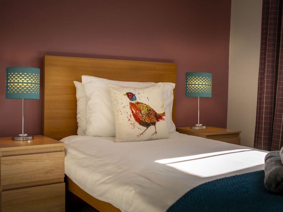 A bedroom with a bed and bedside tables at Clayhills Cottage in Blairgowrie