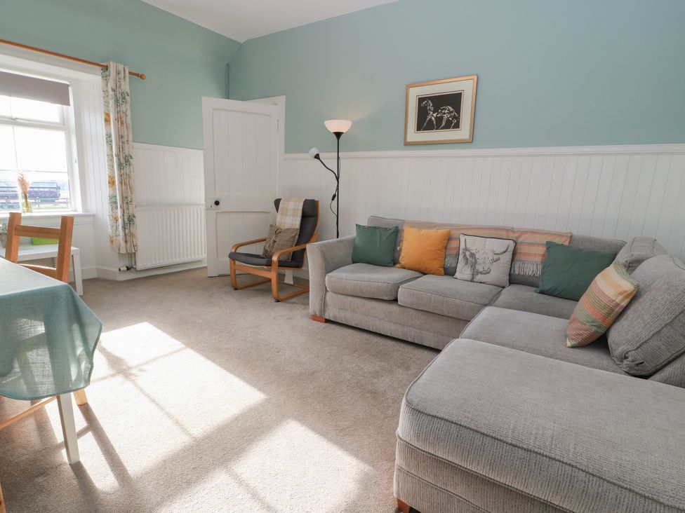 A living room with a sofa and a chair at The Bothy in Blairgowrie