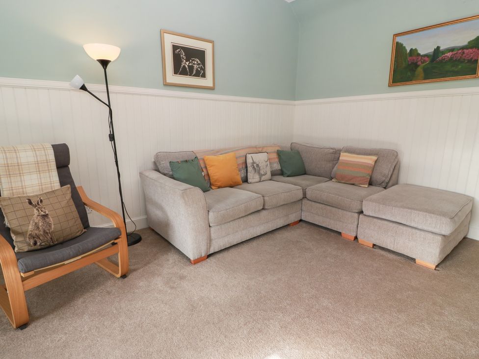 A living room with a sofa and armchair at The Bothy in Blairgowrie