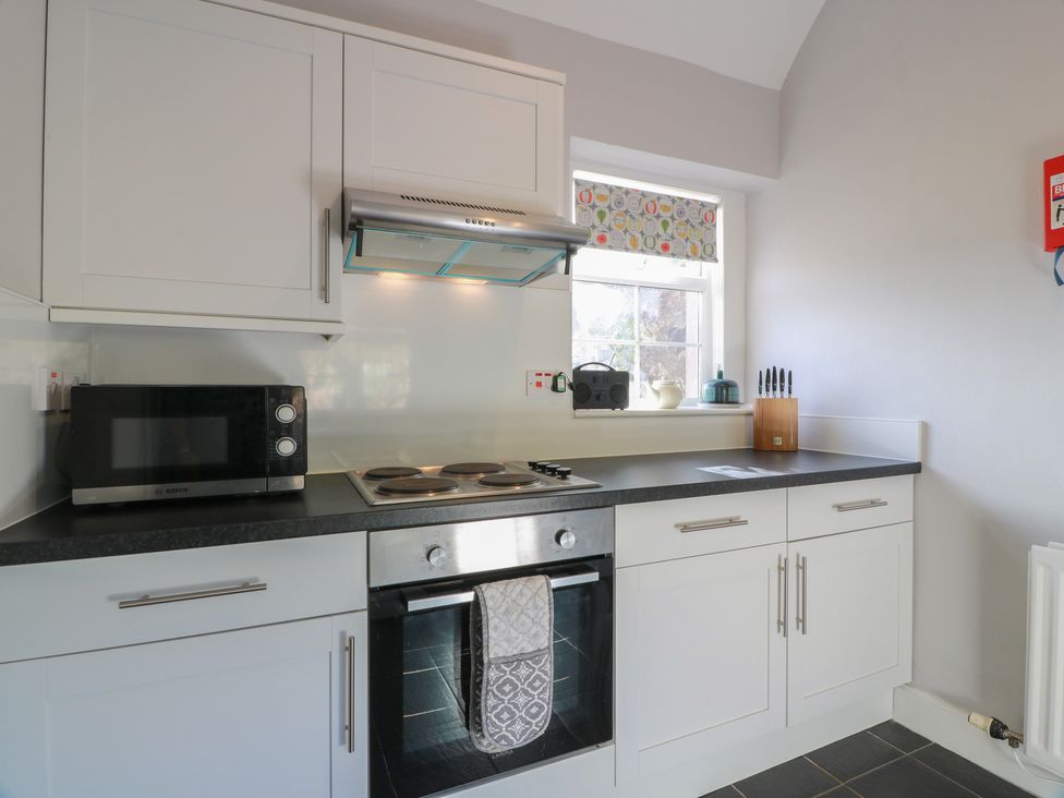 A kitchen with a stove and microwave at The Bothy in Blairgowrie