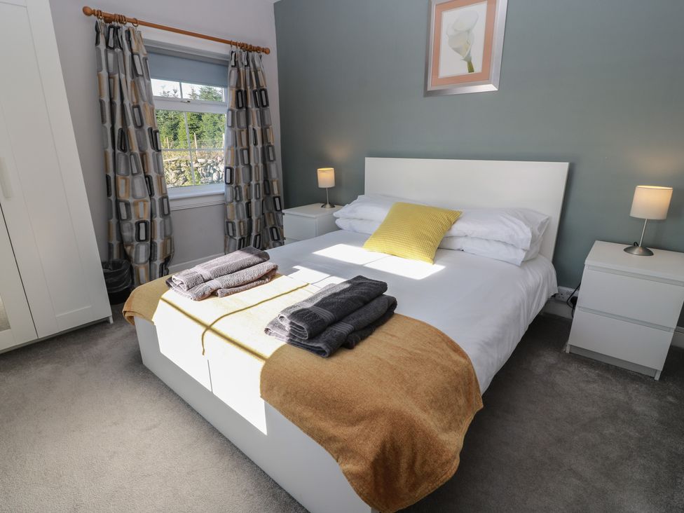 A bedroom with a bed and nightstands at The Bothy in Blairgowrie