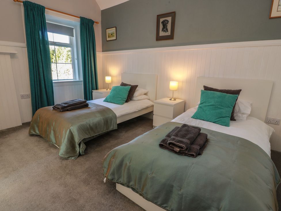 A bedroom with two beds and nightstands at The Bothy in Blairgowrie