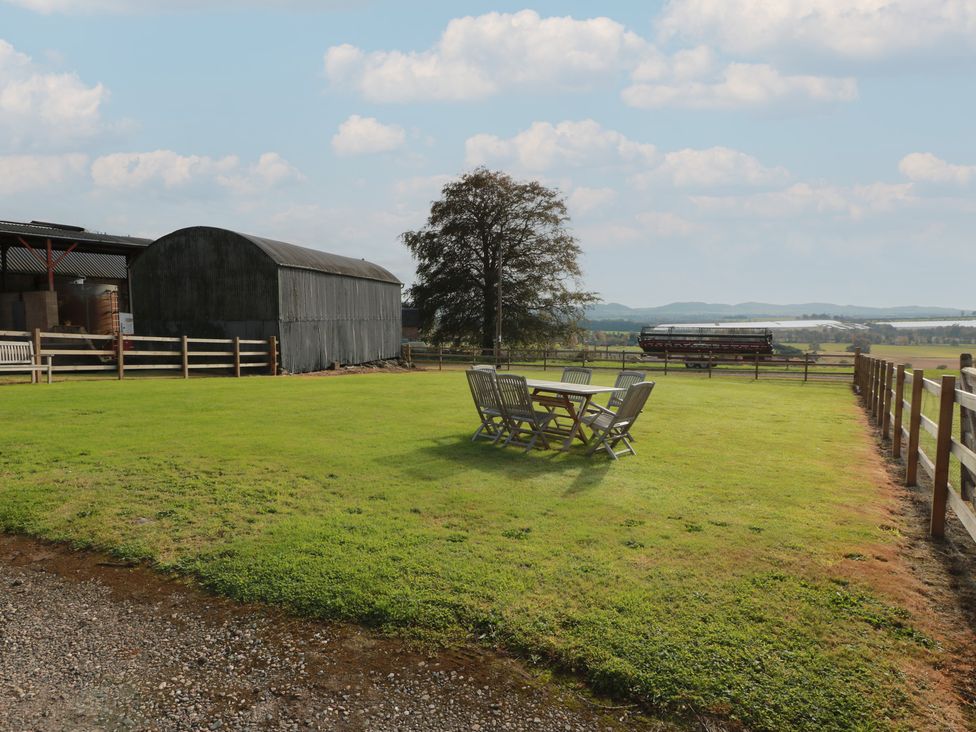 A garden with a table and chairs at The Bothy in Blairgowrie