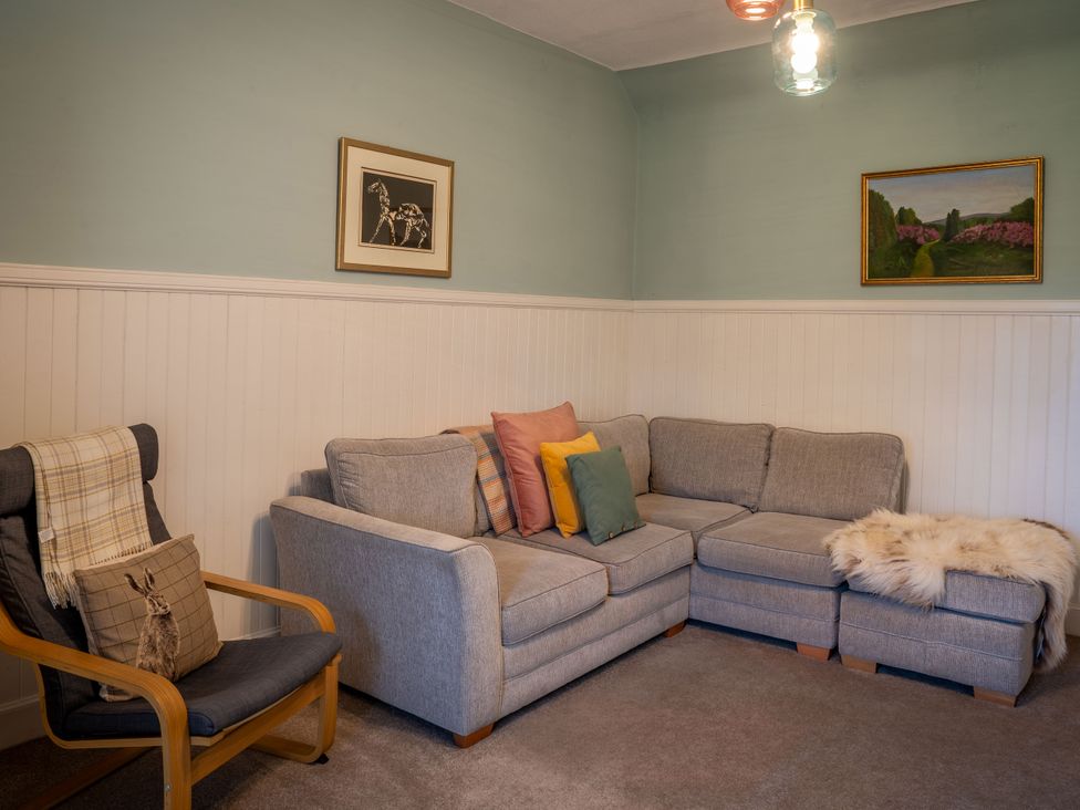 A living room with a sofa and armchair at The Bothy in Blairgowrie