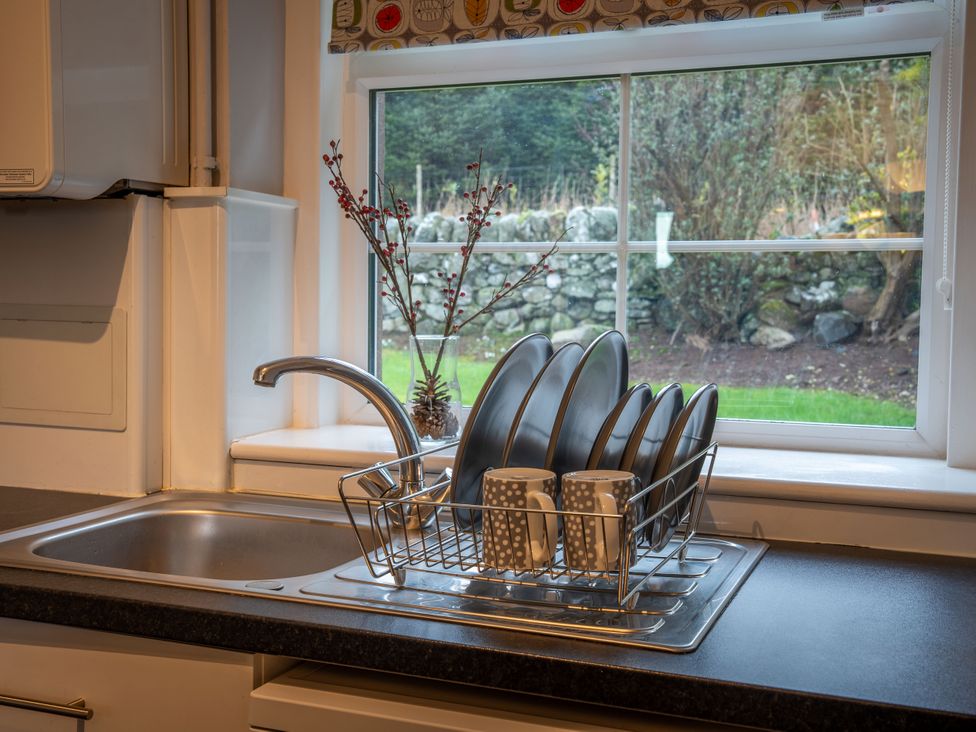 A kitchen with a sink and dish rack at The Bothy in Blairgowrie