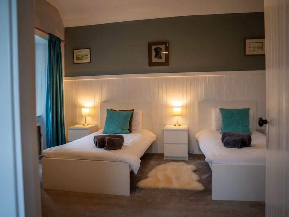 A bedroom with two beds and a nightstand at The Bothy in Blairgowrie