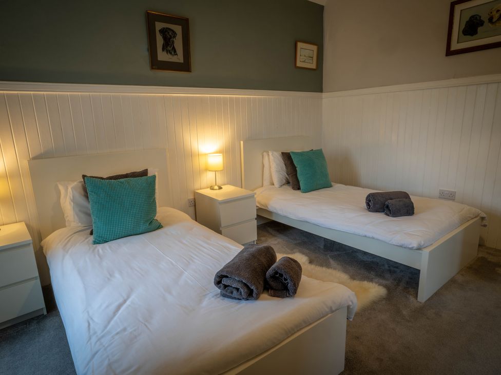 A bedroom with two beds and nightstands at The Bothy in Blairgowrie