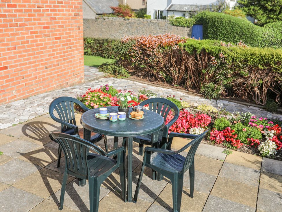 An outdoor seating area with a table and chairs at Gelli - Morfa Nefyn in Morfa Nefyn