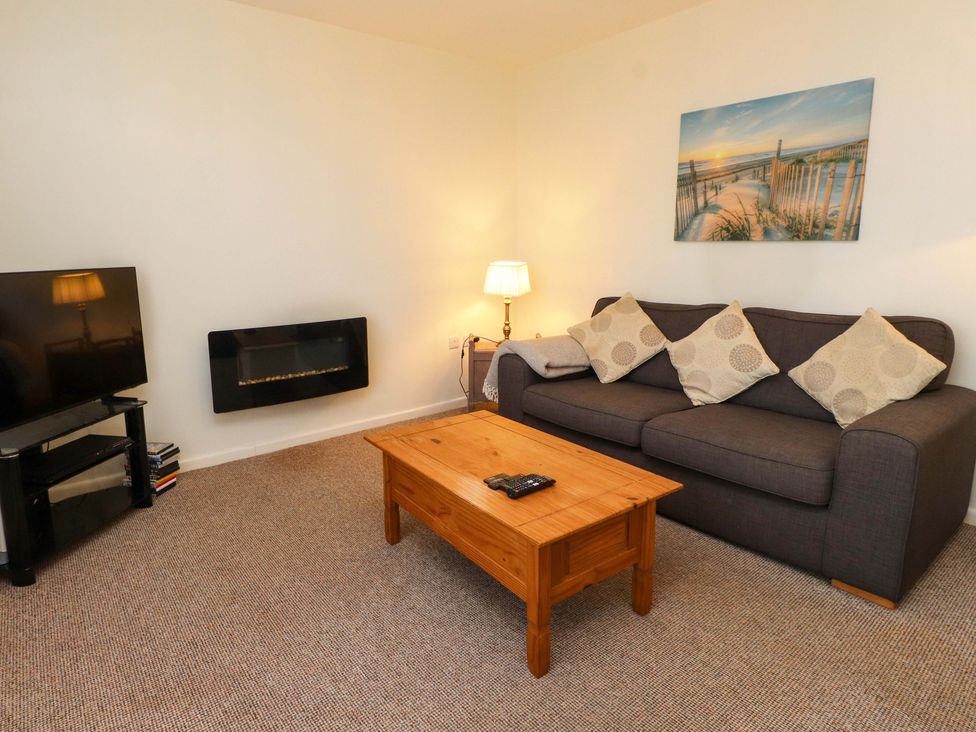 A living room with a sofa and television at Gelli - Morfa Nefyn Morfa Nefyn