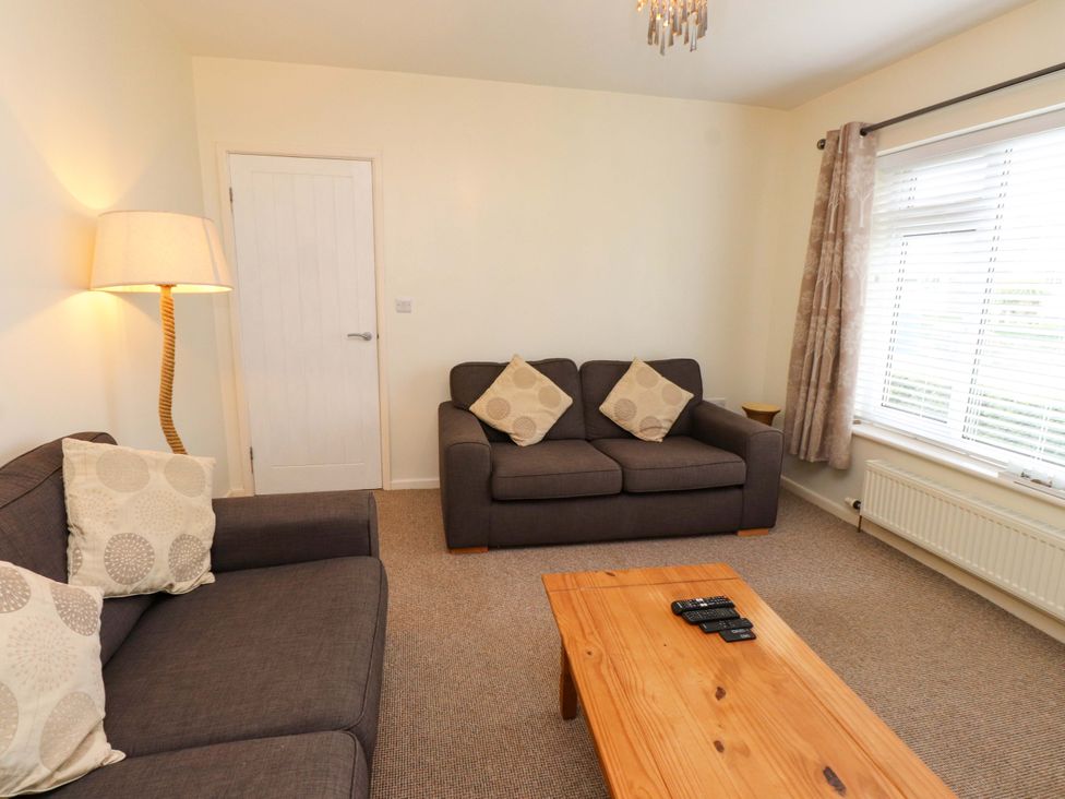 A living room with two sofas, a lamp, and a coffee table at Gelli - Morfa Nefyn in Morfa Nefyn