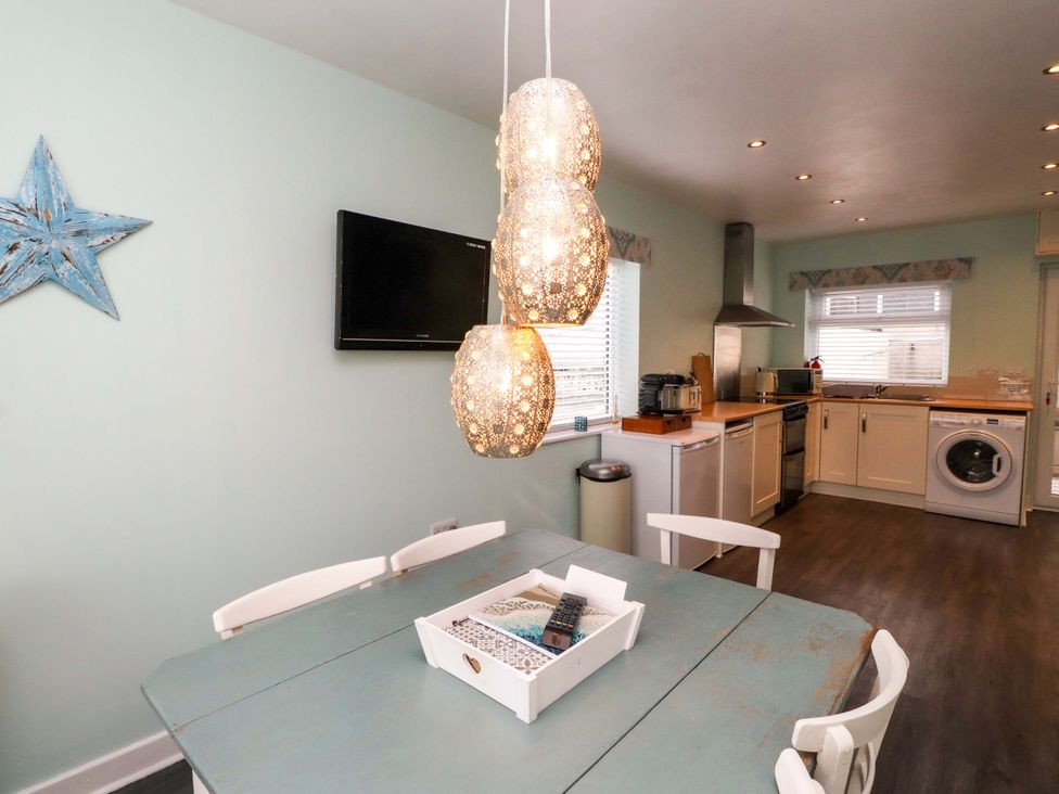A kitchen with a table and chairs at Gelli - Morfa Nefyn in Morfa Nefyn