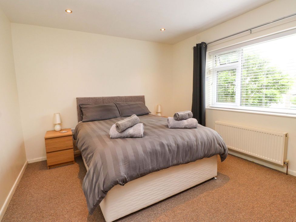 A bedroom with a bed and bedside table at Gelli - Morfa Nefyn in Morfa Nefyn