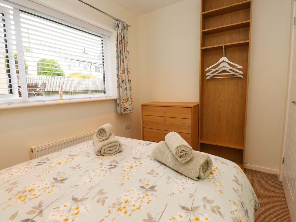 A bedroom with a bed and towels on top at Gelli - Morfa Nefyn in Morfa Nefyn