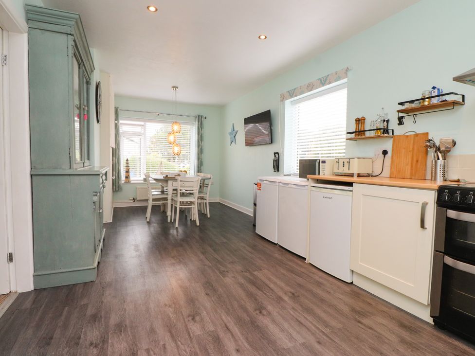 A kitchen with a table and chairs at Gelli - Morfa Nefyn
