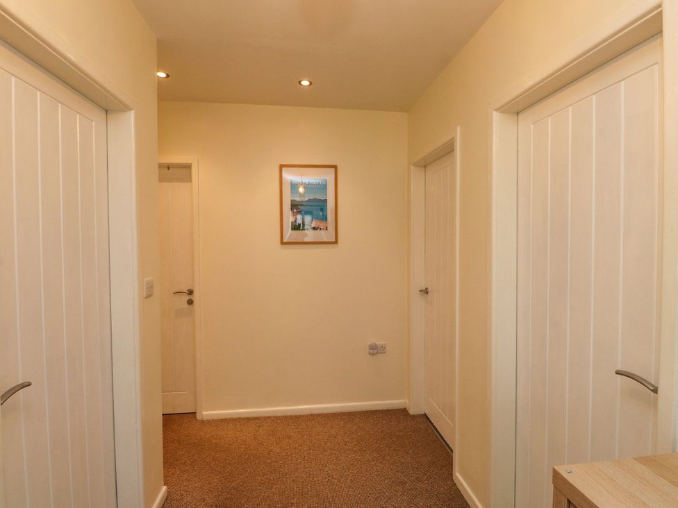 A hallway with doors and a picture frame at Gelli - Morfa Nefyn in Morfa Nefyn