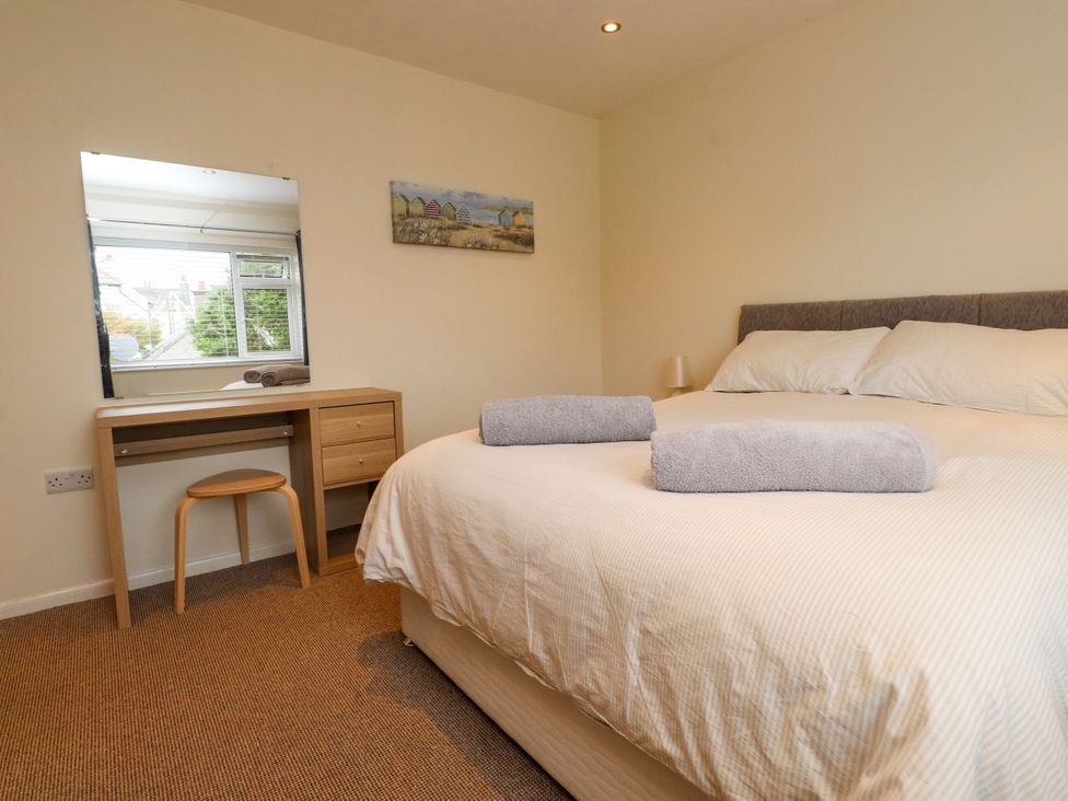 A bedroom with a bed and a desk at Gelli - Morfa Nefyn in Morfa Nefyn