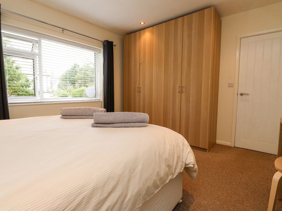 A bedroom with a bed and wardrobe at Gelli - Morfa Nefyn