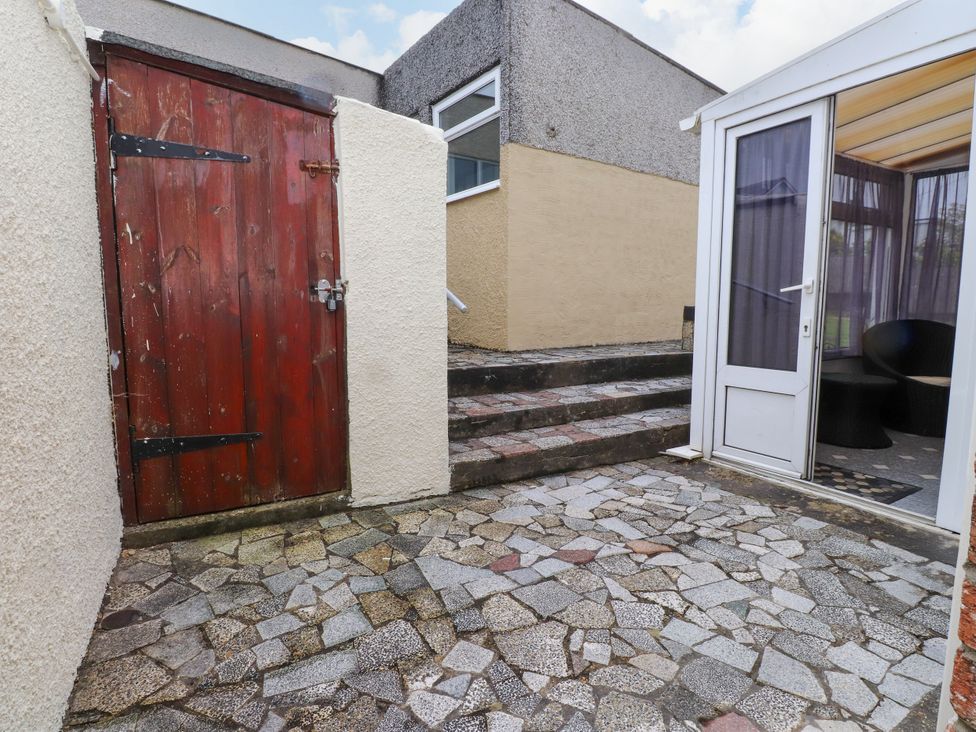An outdoor area with a wooden door and steps at Gelli - Morfa Nefyn in Morfa Nefyn