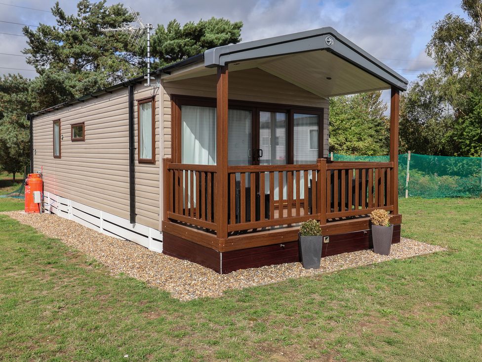A caravan with a deck and planters at Stag Lodge, Caravan 70 Great Yarmouth