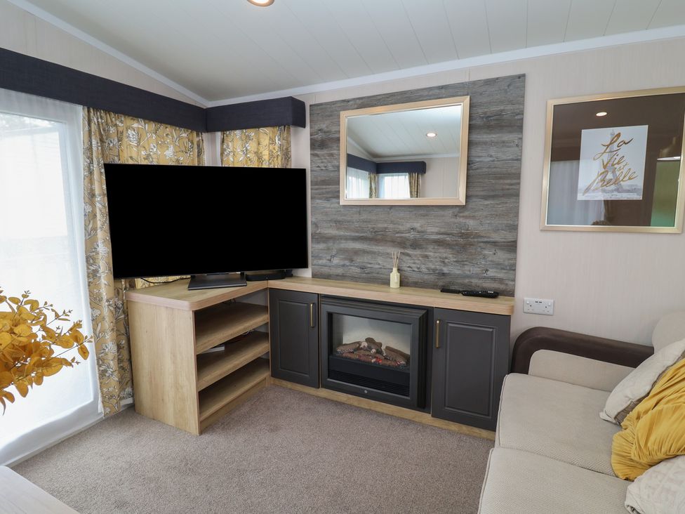 A living room with a television and fireplace at Stag Lodge, Caravan 70, Great Yarmouth