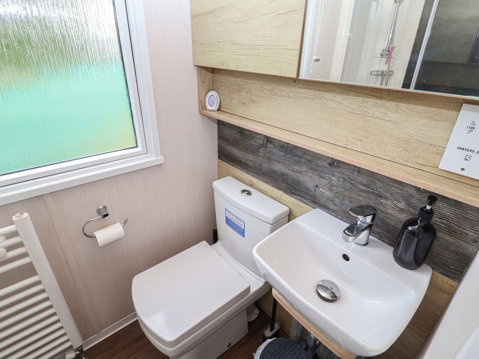 A bathroom with a toilet and sink at Stag Lodge, Caravan 70, Great Yarmouth