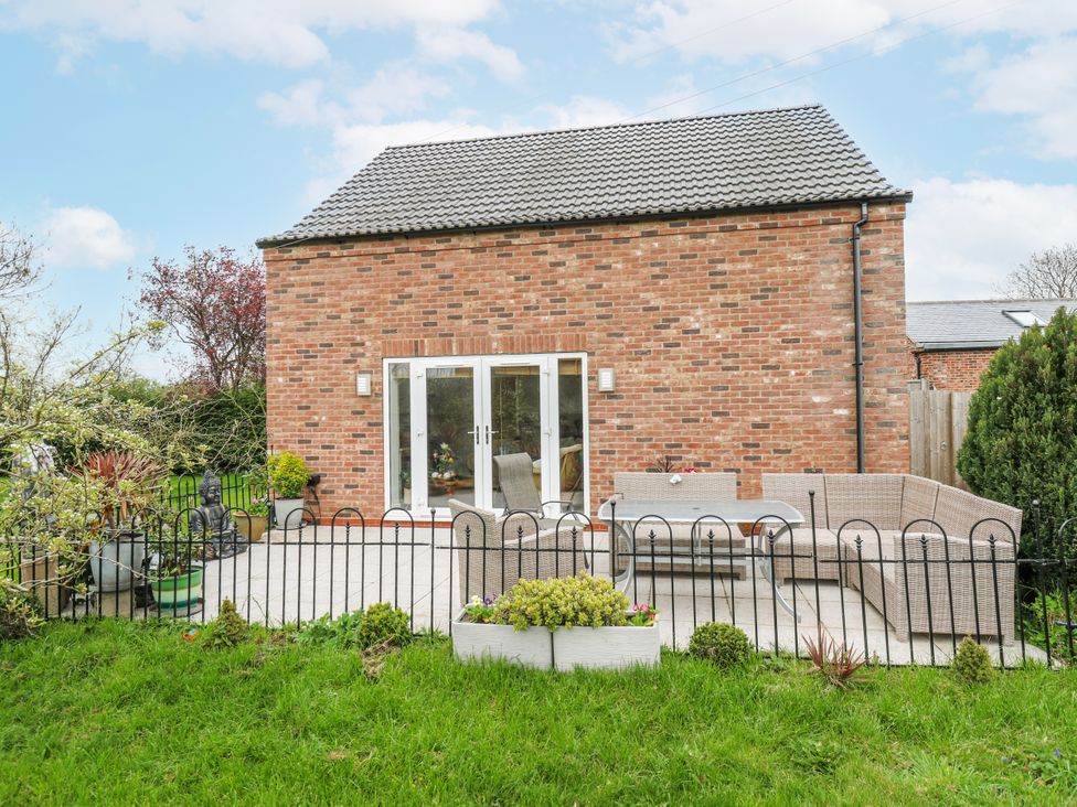 A garden with a patio and outdoor furniture at The Retreat in 