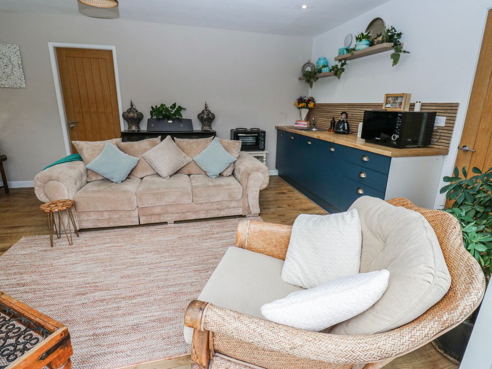 A living room featuring a sofa and kitchen cabinet at The Retreat 