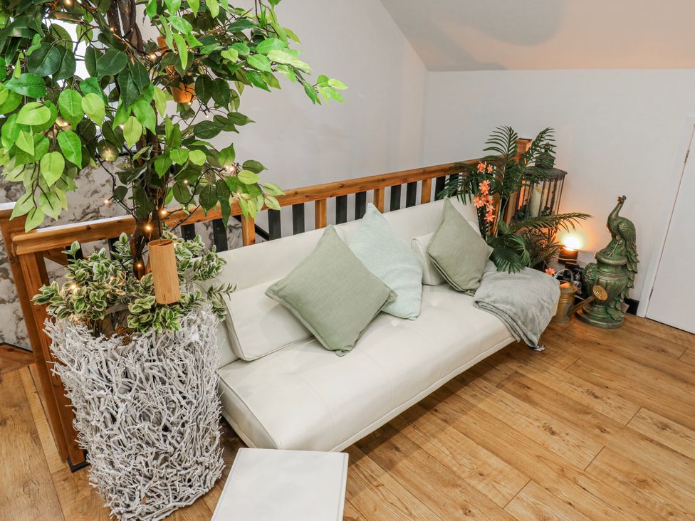 A living room with a sofa and plants at The Retreat in 