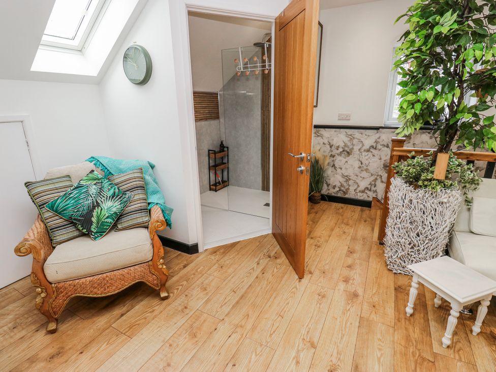 A bathroom with a shower door and seating area at The Retreat in 