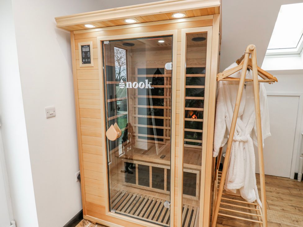 A sauna with wooden interior and a robe on a hanger at The Retreat in 