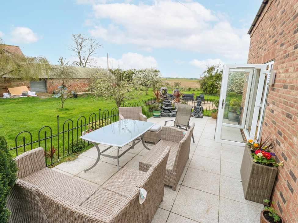 A garden with patio seating and table at The Retreat in 