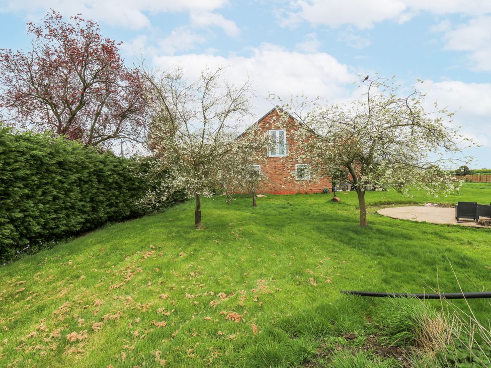 A garden with trees and a house at The Retreat in 