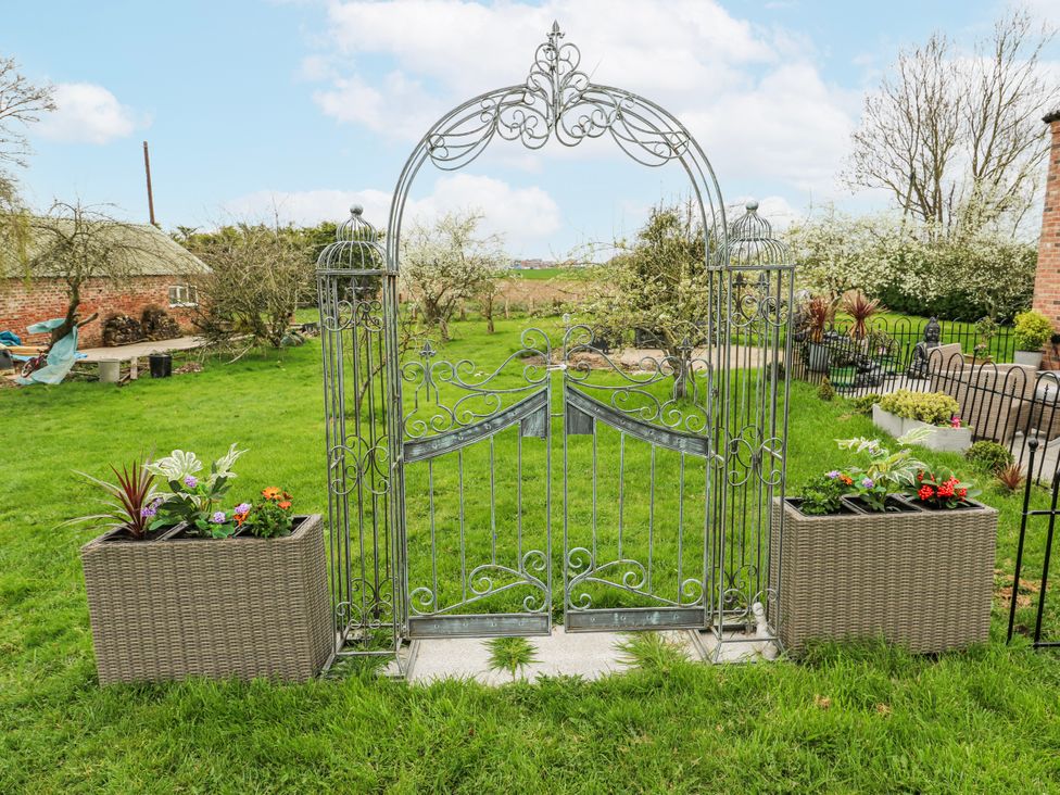 A garden with a metal gate and flower planters at The Retreat in 