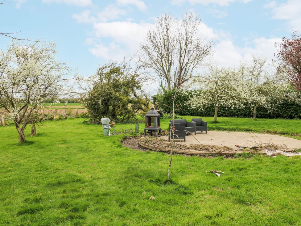 A garden with chairs and a table near a firepit at The Retreat