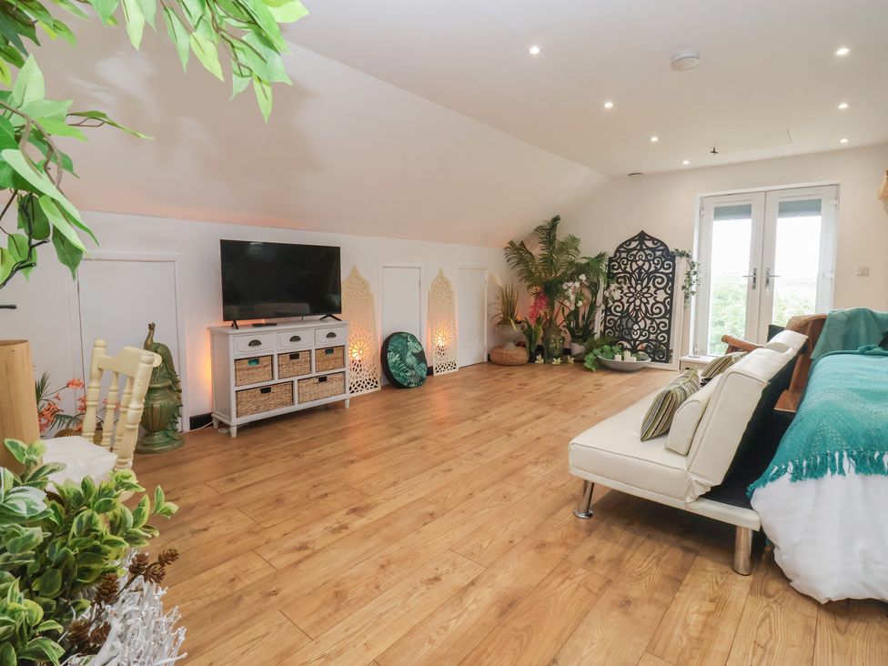 A living room with a television and sofa at The Retreat in Snaith