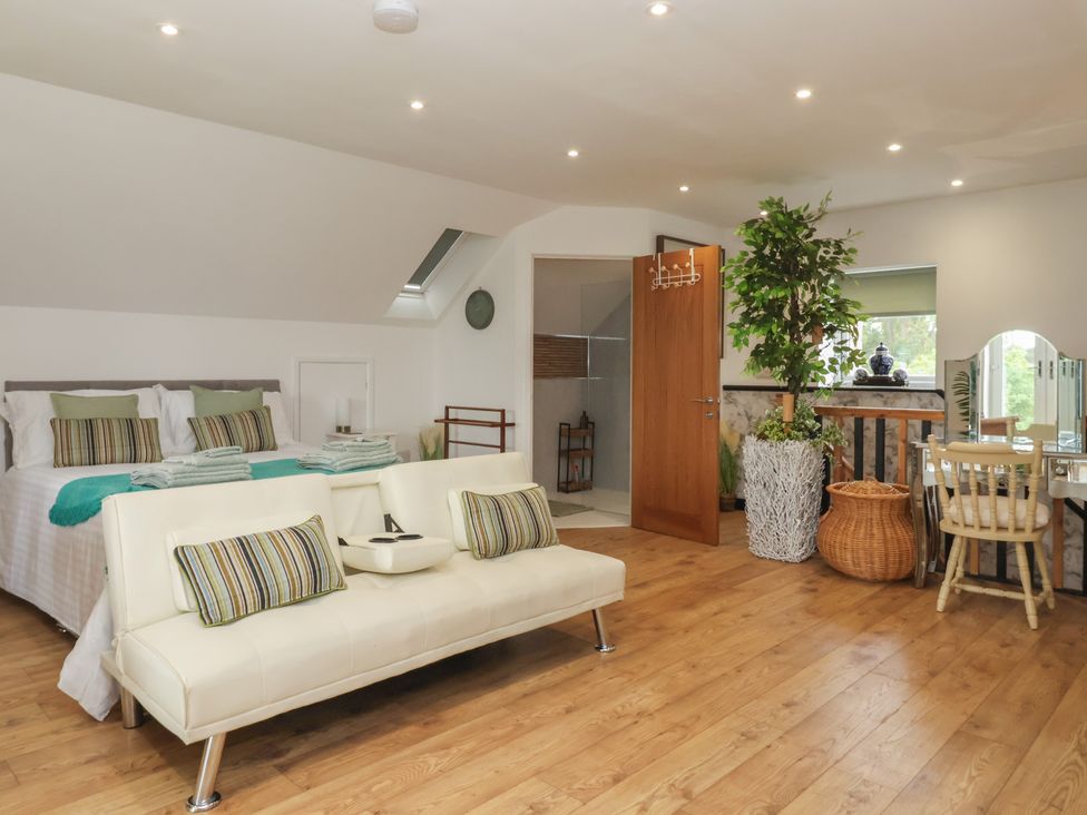 A bedroom with a bed and seating area at The Retreat in Snaith