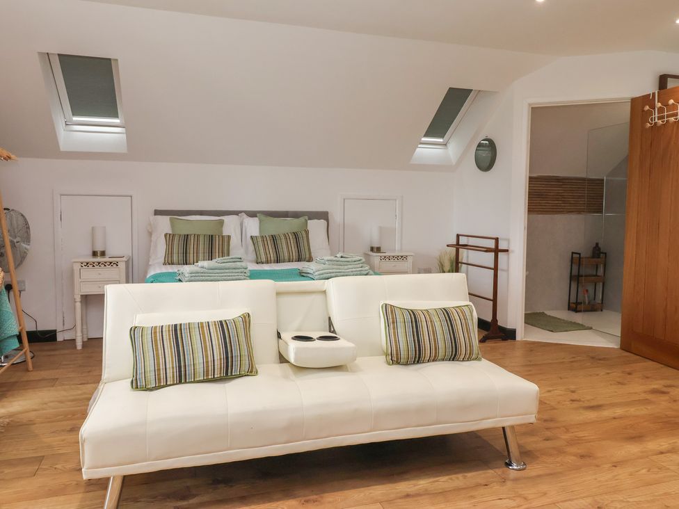 A bedroom with a bed and sofa at The Retreat in Snaith