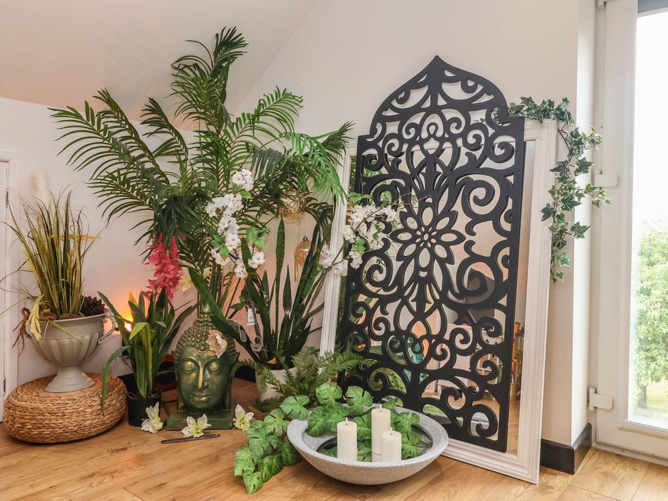 A decorative arrangement with a buddha statue and potted plants at The Retreat in Snaith