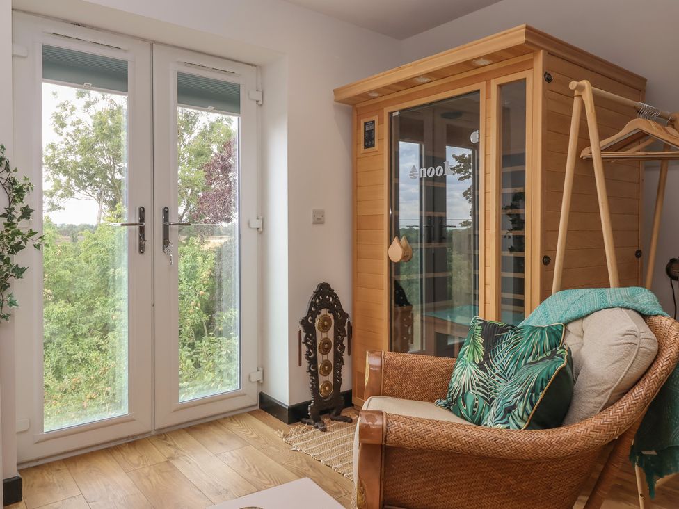A snug with an armchair and sauna at The Retreat in Snaith