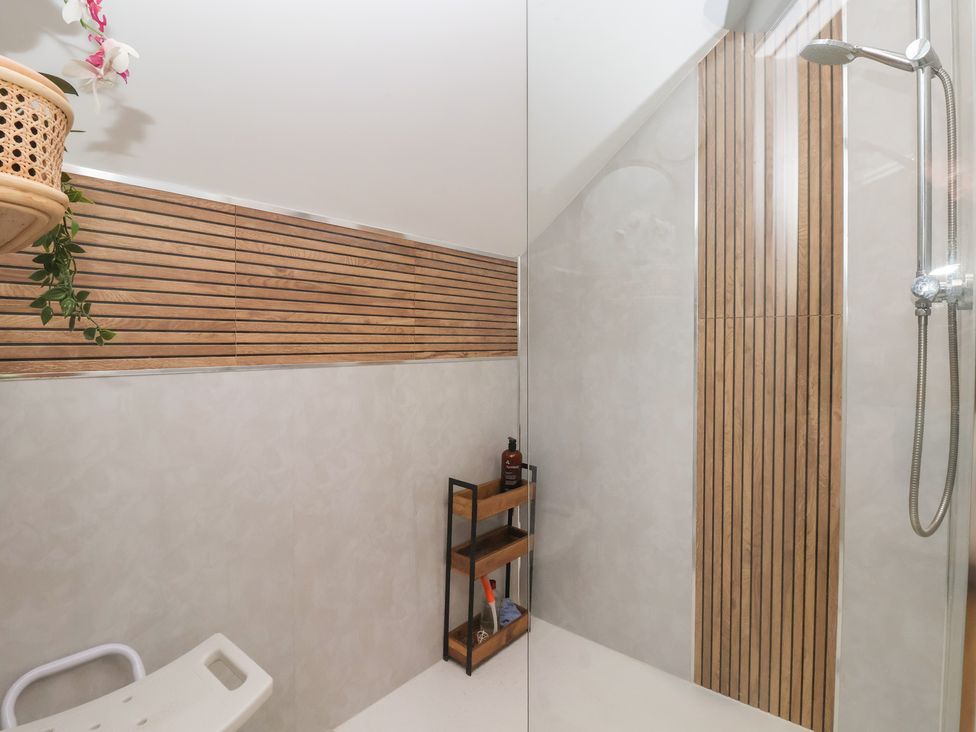 A shower with a shelf and plant in a bathroom at The Retreat in Snaith