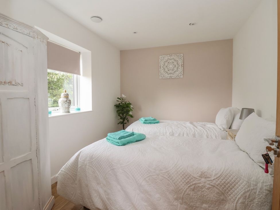 A bedroom with two beds and a wardrobe at The Retreat in Snaith
