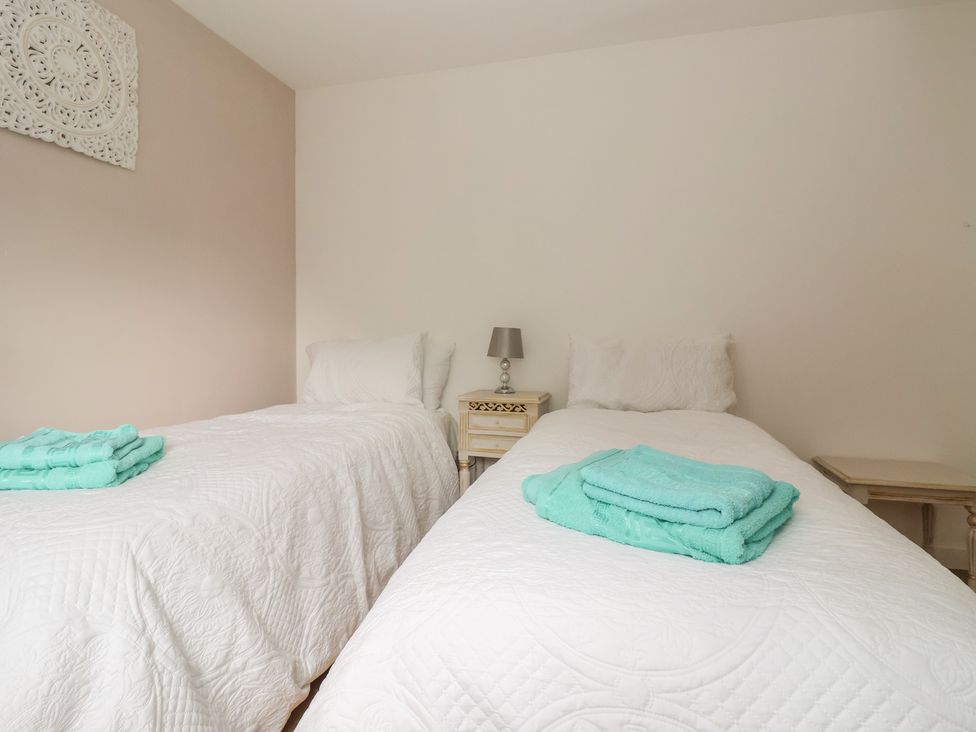 A bedroom with twin beds and towels on top at The Retreat in Snaith