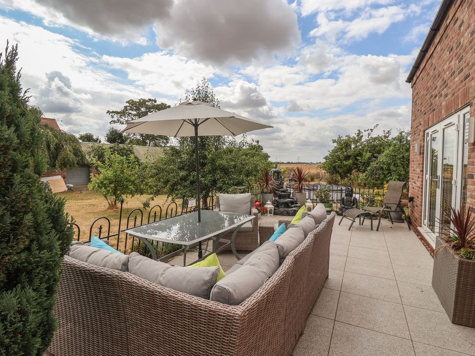 An outdoor seating area with a table and parasol at The Retreat in Snaith