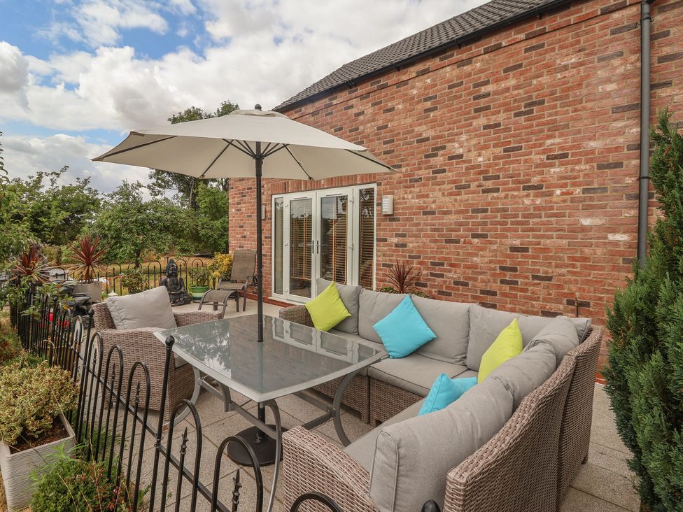 An outdoor seating area with a table and sofa at The Retreat in Snaith