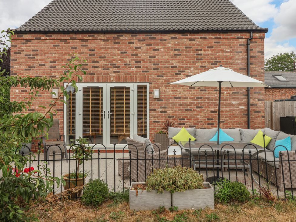 A garden with seating and a parasol at The Retreat in Snaith
