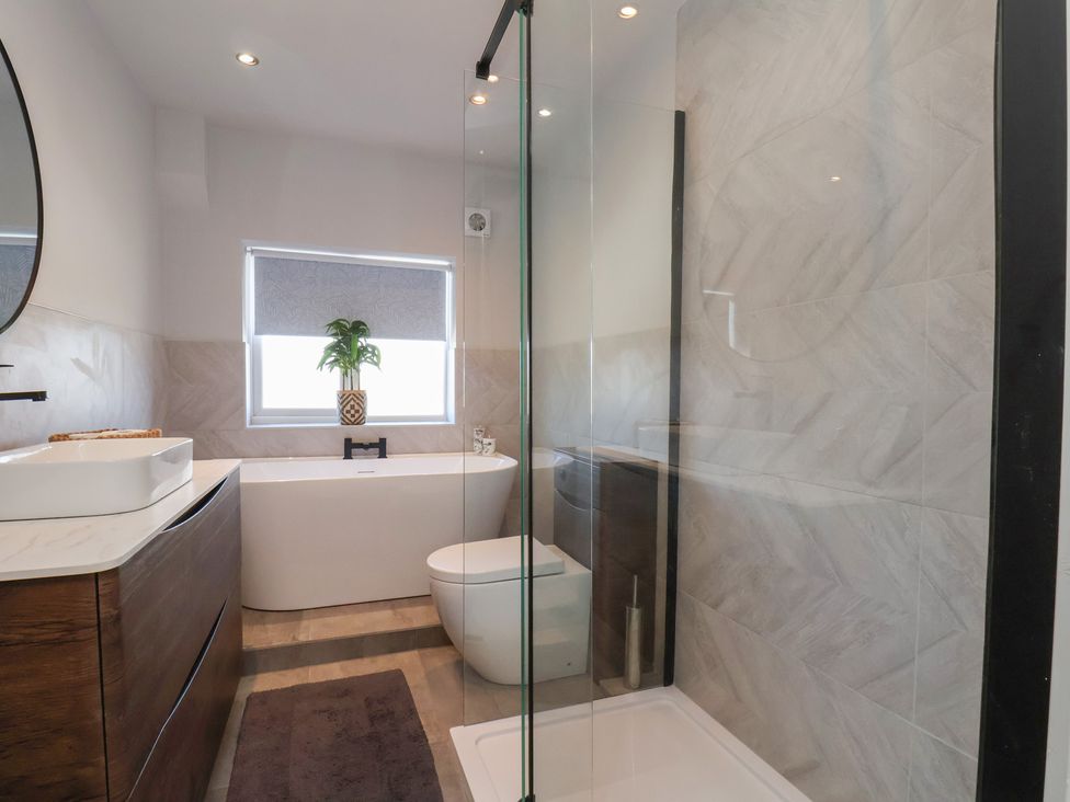 A bathroom with a shower, bathtub, toilet, and sink at Falcon Luxe in Whitby