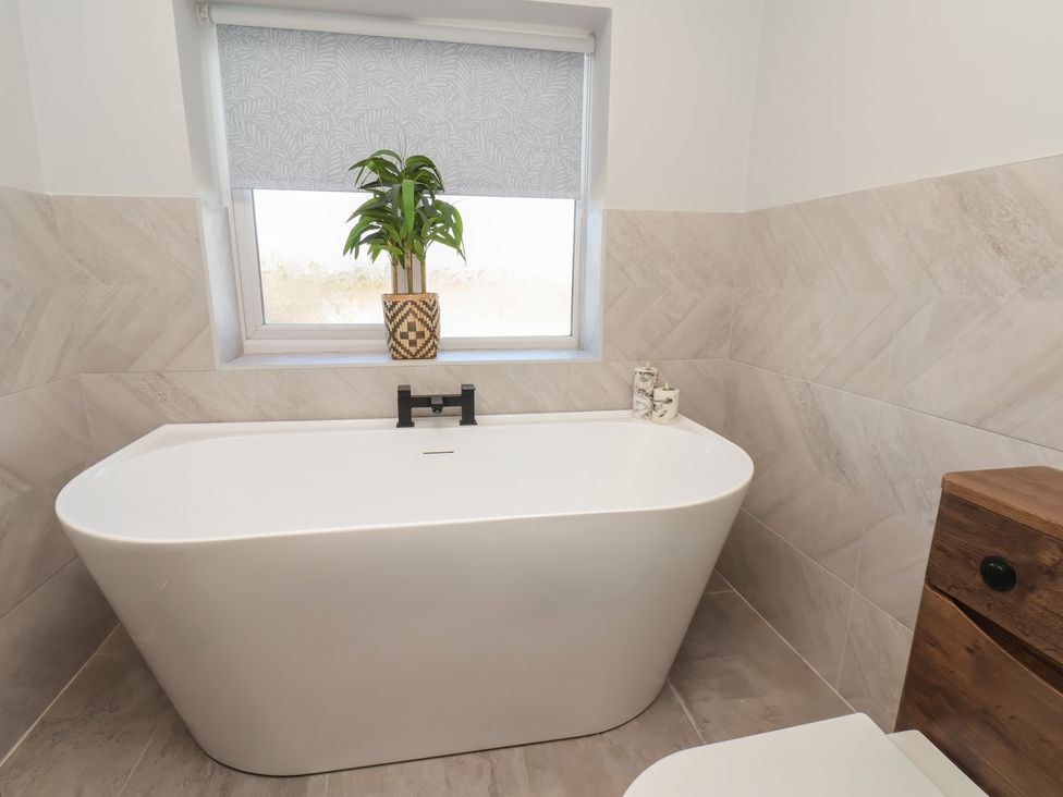 A bathroom with a bathtub and a toilet at Falcon Luxe in Whitby